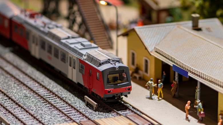 Oyuncak figürinli kırmızı ve gri model bir tren.