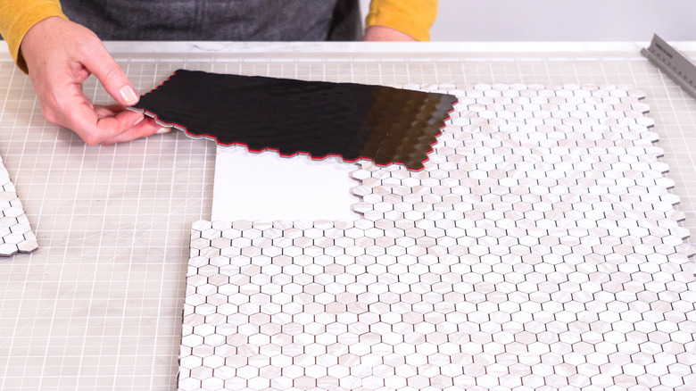 Bir soy ve yapışmaz karo bölümü tutan bir el