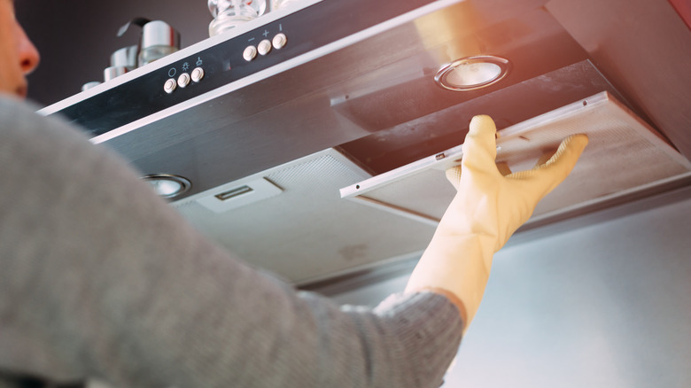 Kadın soba kaputunu çıkarıyor