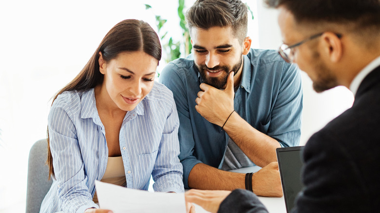 Bir emlakçı, bir çiftle bir teklifi inceliyor