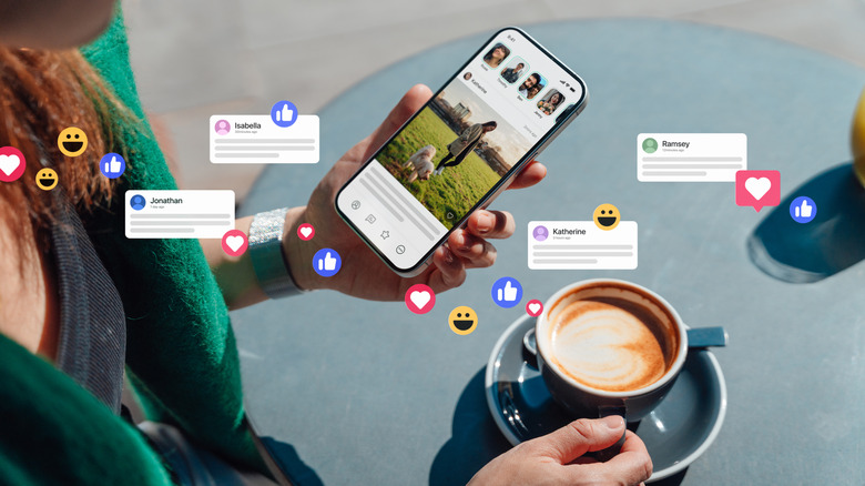 Bir kafede kahve içerken telefonuyla topluluk grubuyla etkileşime giren kadın