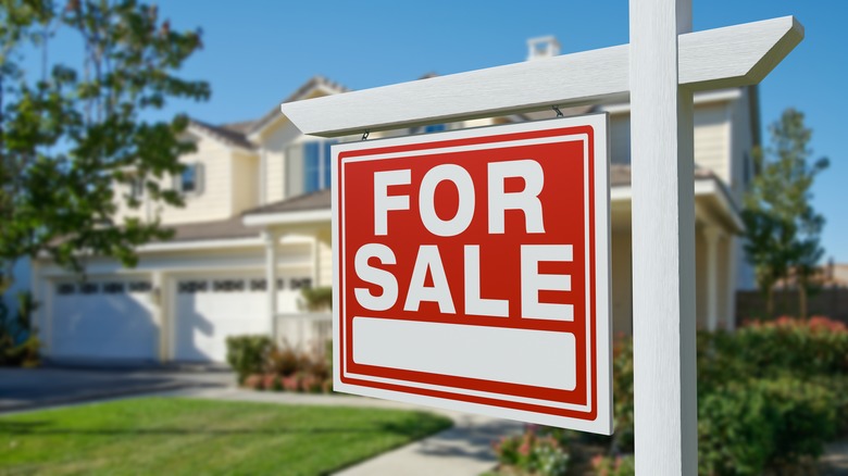 Beyaz evin önünde Satılık tabelası