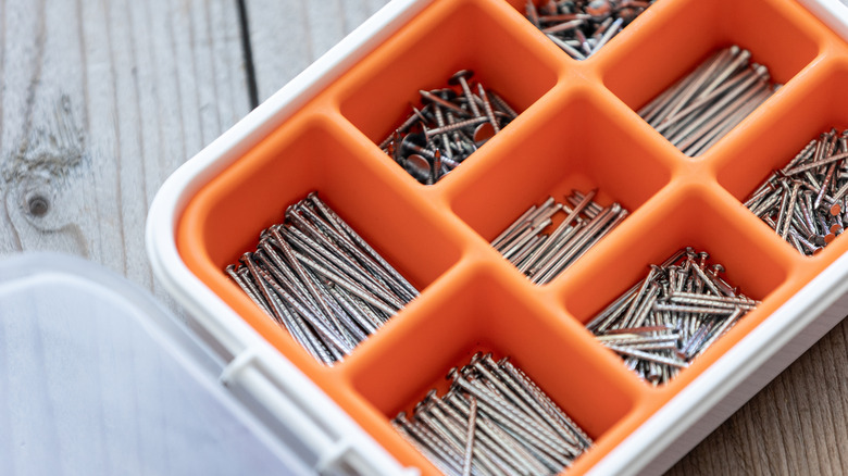 Bölmelerde vidalar bulunan turuncu ve beyaz kutu.