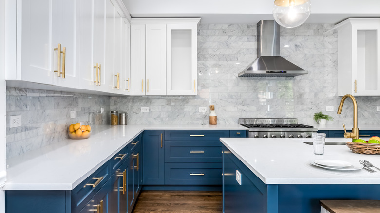 Beyaz tezgahlı, beyaz üst dolaplı, mavi alt dolaplı modern mutfak.