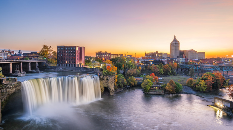 Rochester, New York gün batımında ön planda bir şelaleyle görülüyor.