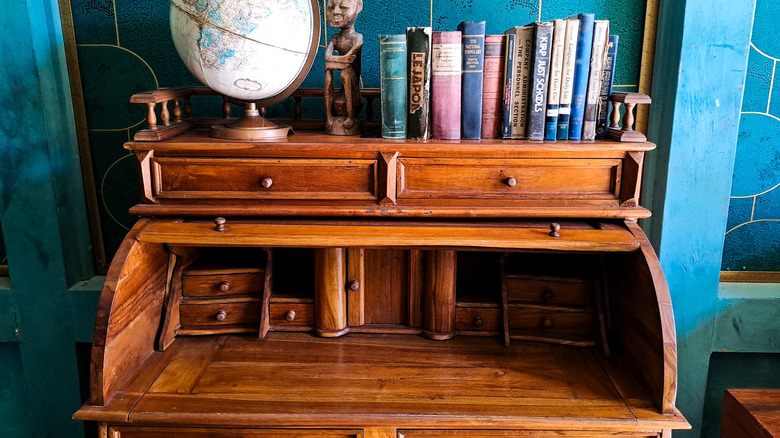 Üzerinde kitaplar ve küre bulunan yenilenmiş antika bir masa