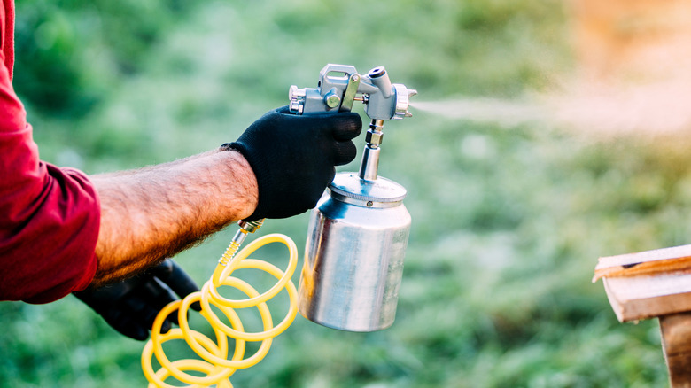 Boya püskürtücü kullanan kişi