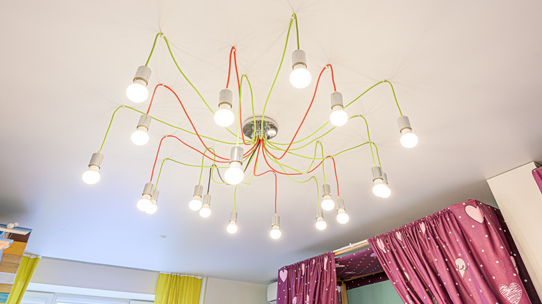 Bir çocuğun yatak odasında tonlarca açıkta ampul bulunan harika bir tavan aydınlatma armatürü