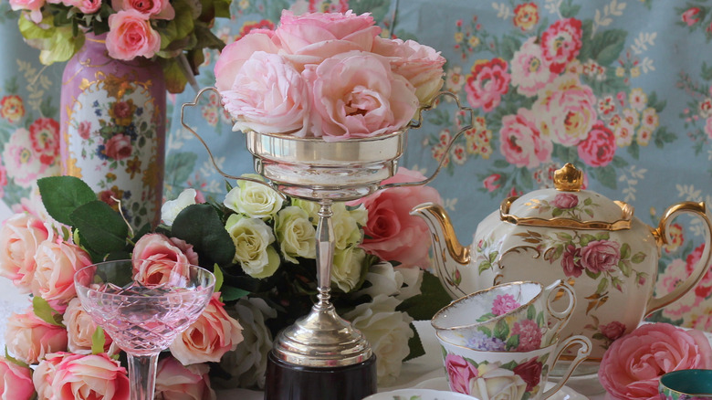 Masa manzarasında çiçekleri tutmak için kullanılan vintage gümüş kupa