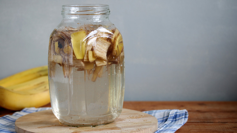 Muz kabukları ve sirkeyle dolu bir cam şişe.
