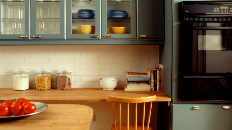 Yerleşik çalışma masası ve ahşap sandalye ile modern görünümlü bir mutfak.