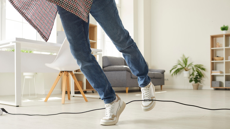 Oturma odasında bir kişinin kabloya takılıp düşmesi.