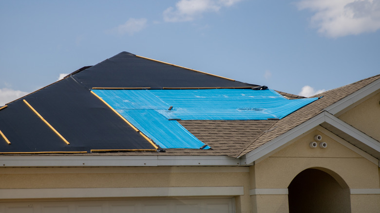 Çatısı yenilenen bir evin üzerindeki branda.