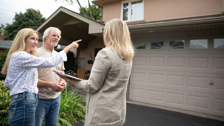 Garajın önünde potansiyel alıcılarla emlakçı