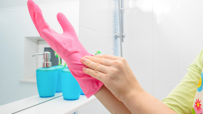 Banyoda pembe eldiven giyen kişi