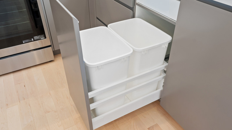 Gümüş fırını ve beyaz çöp kutusu olan bir mutfak. Çöp kutusu diğer iki çöp kutusuyla birlikte bir çekmecede.