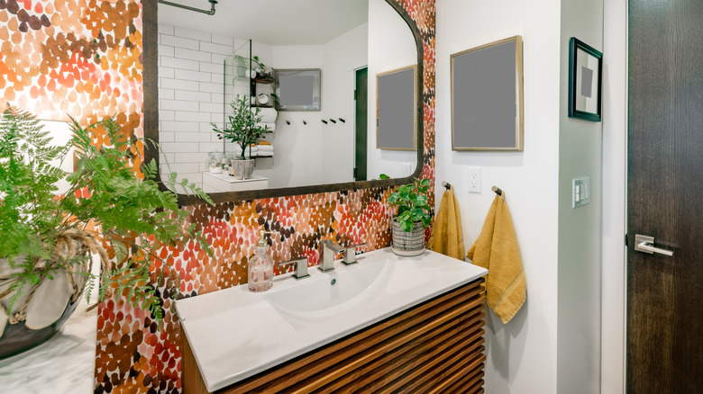 Renkli duvar kağıdı, yeşillik ve dekora sahip eklektik ikinci banyo makyaj masası