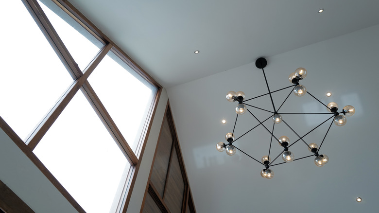 Yüksek tonozlu tavandan sarkan büyük siyah bir avize