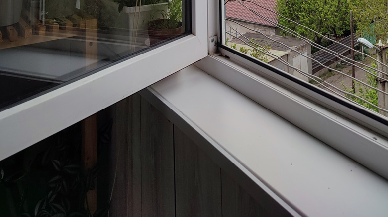 Dışarıdaki bulutlu günü gösteren açık bir pencere.