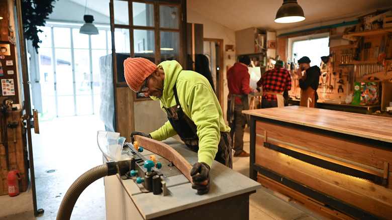Bir marangoz atölyede bir mobilya parçası yaratıyor.