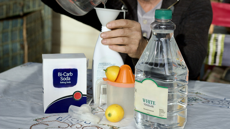 Birisi kabartma tozu ve limonun yanına spreylemek için sirke ekliyor.