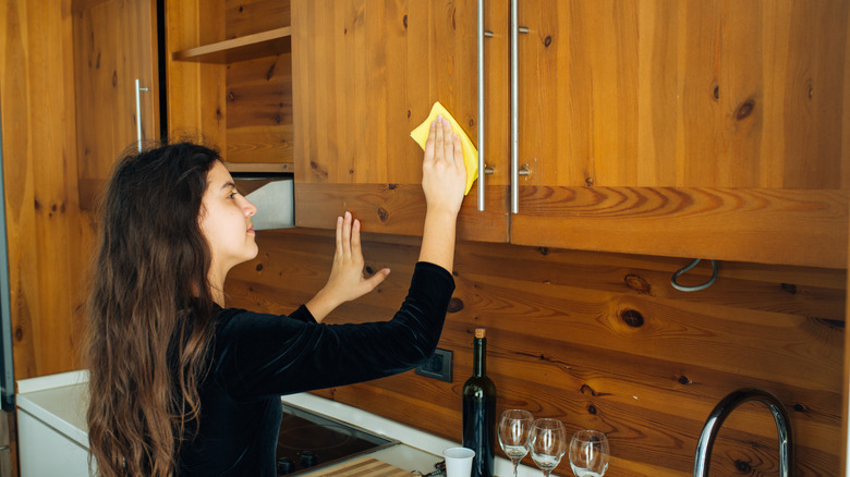 ahşap panelli mutfağı temizleyen kız