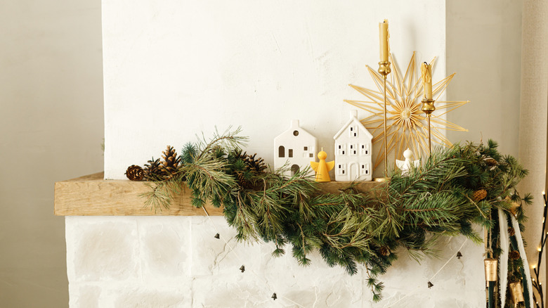 Mumlar ve yeşilliklerle süslü bir şömine rafı