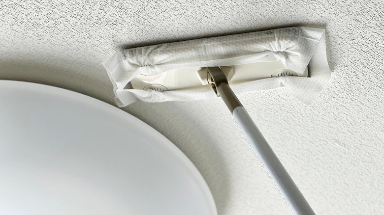 Tek kullanımlık mikrofiber paspasla dokulu bir tavanın temizlenmesi.