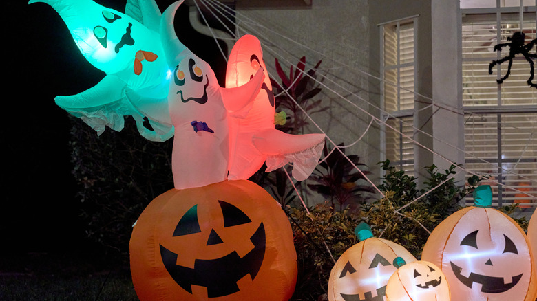 Bahçedeki bir evin önünde şişirilebilir hayaletler ve fenerler