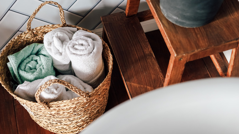 Dokuma bir sepete sarılmış beyaz ve açık mavi havlular