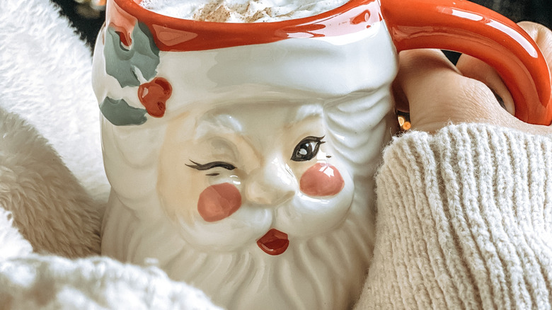 Vintage Noel Baba kupası tutan kişi