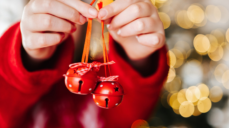 Kırmızı Noel çanları tutan kişi