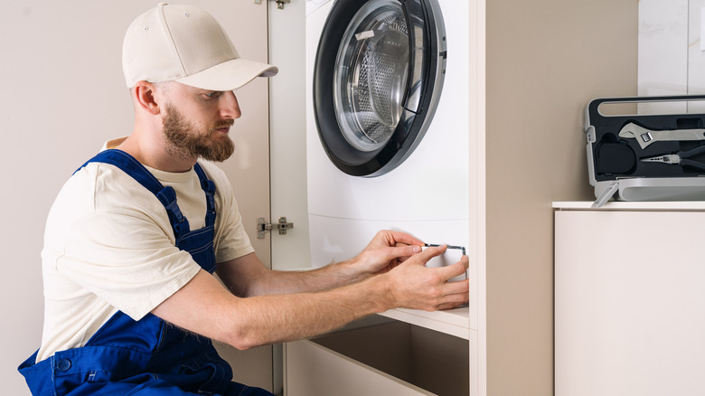 Ön yükleyici filtre kapısını açan adam