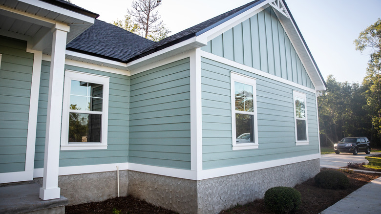 Beyaz süslemeli ve pencereli tozlu mavi ev