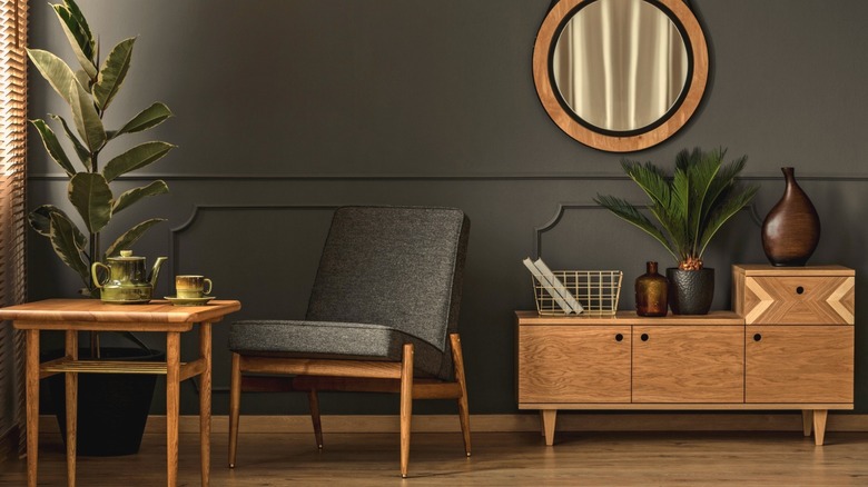 Koyu gri duvarlar ve sıcak ahşap mobilyalarla donatılmış bir oturma odası.