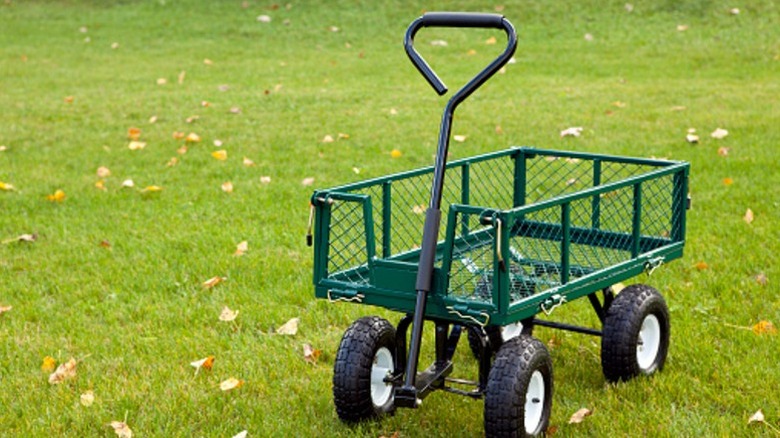 Kenarları örgülü ve arazi lastikleriyle donatılmış çelik bir bahçe arabası.