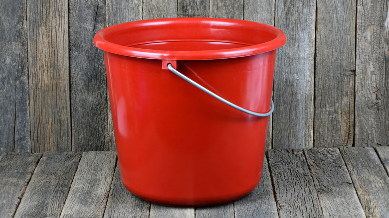 Ahşap arka planlı kırmızı kova