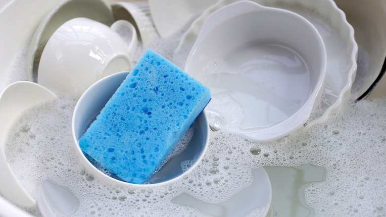 Lavaboda süngerle ıslanan bulaşıklar