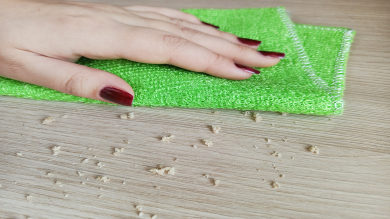 Tezgahı silmek için bambu kumaş kullanan kadının yakın çekimi