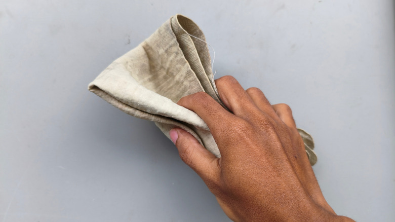 Güderi kumaş havluyla yüzeyi silen kişinin yakın çekimi