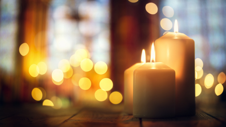 Bir oda birçok mumun ışığıyla parlıyor.