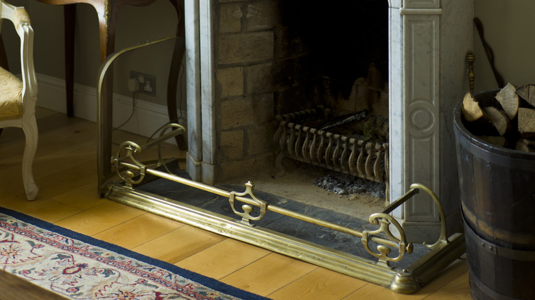 Mermer şöminenin yanındaki klasik şömine çamurluğu