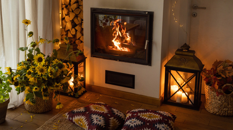 Fener mumluklarıyla çevrili rahat iç mekan şöminesi