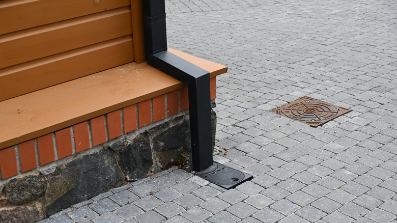 Siyah ahşap kaplamayla kaplı drenaj borusunun kapatılması