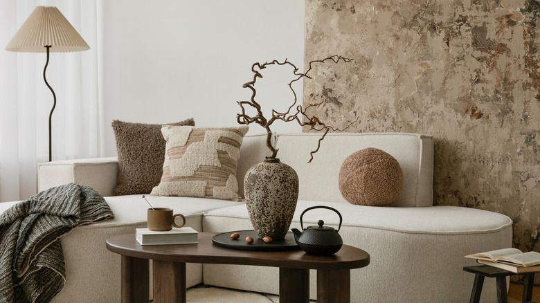 Arka planda dokulu duvarlı Japandi tarzı oturma odası