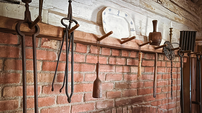 19. yüzyıl tarzı şömine rafı ve metal aletlerle donatılmış şömine düzeni.