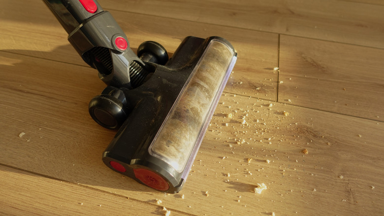 Açık renkli parke zemindeki kırıntıları vakumla toplama