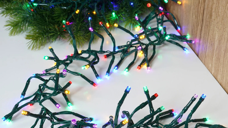Bir Noel ağacının tabanının yakınında yerde çok renkli bir küme pırıltı ışık dizisi yatıyor