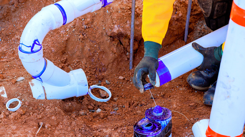 Konut kanalizasyon hattı için PVC boru bağlayan işçi
