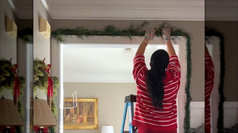 Kadın sahte çelenkini yeşilliklerle yeniliyor